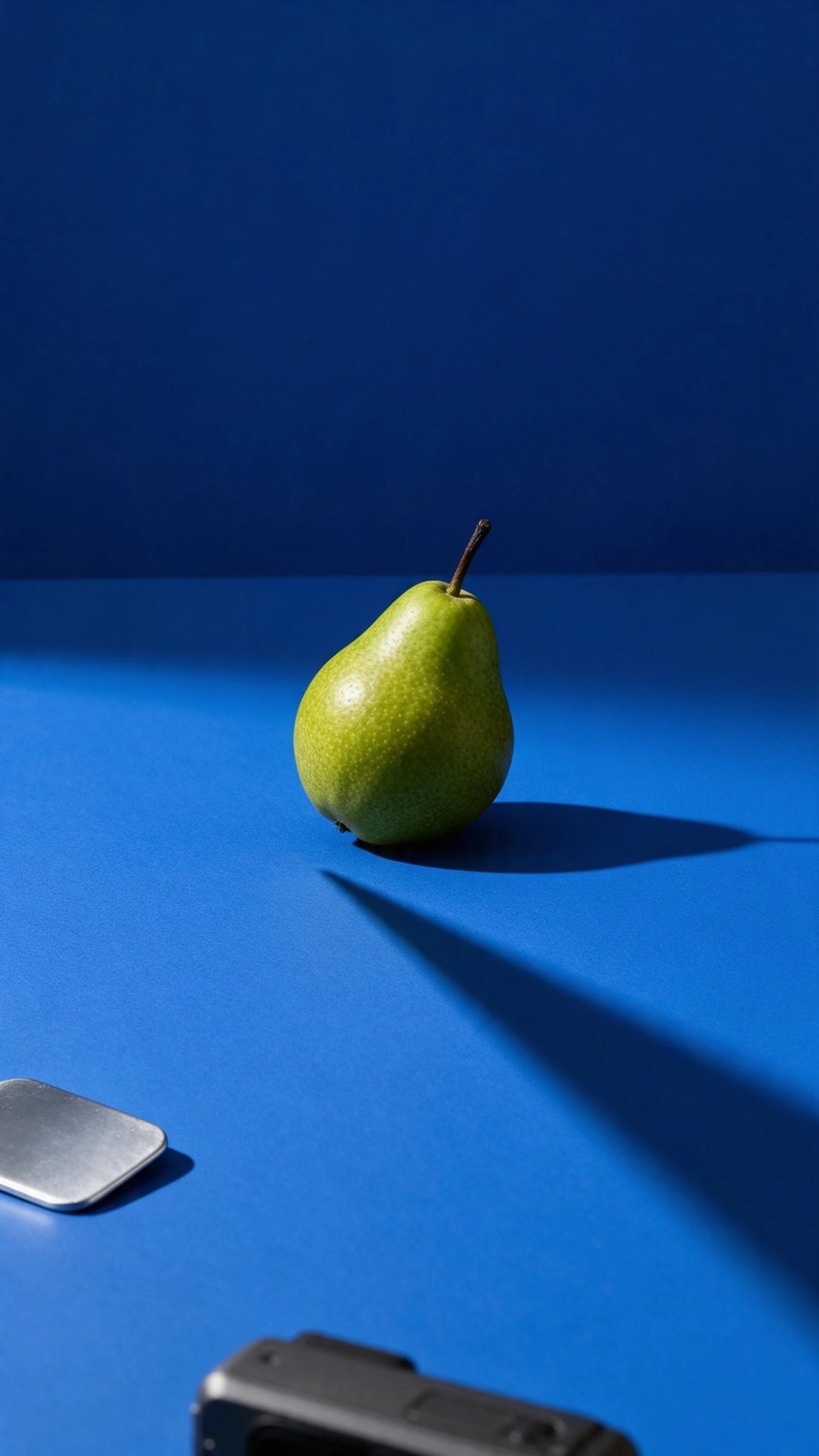 AI-generated source image of a green pear and its shadow on a blue surface with a reflector and cropped camera