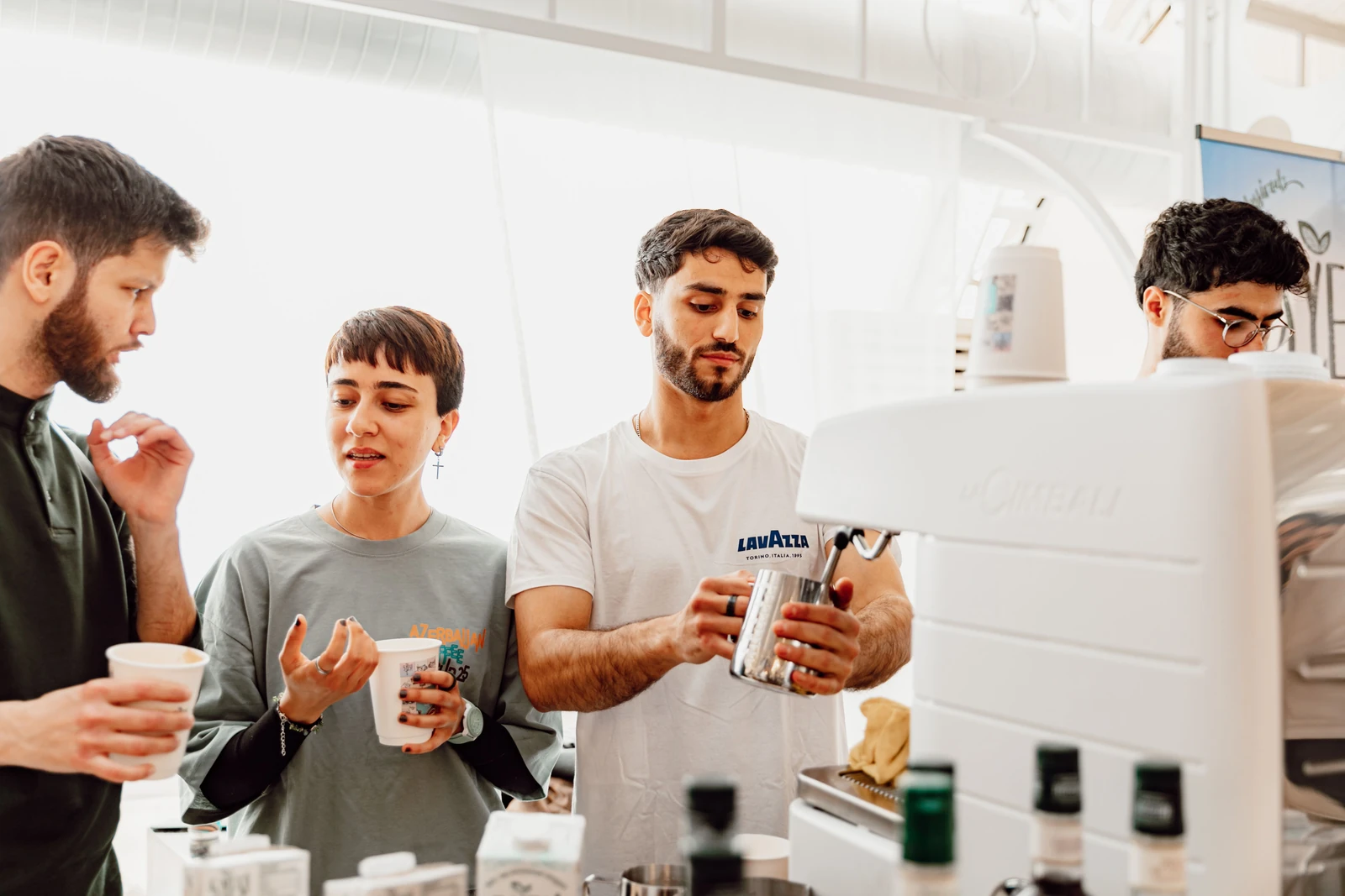 Supplied photograph of adults learning to use an espresso machine in a coffee workshop